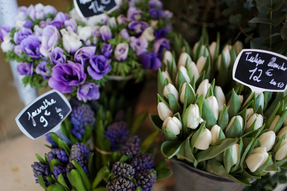 A close-up view of fresh floral bouquets featuring purple and white flowers at an enfieldflowers.org.uk flower shop. On the left, a bouquet of purple lisianthus and small purple hyacinths is partially